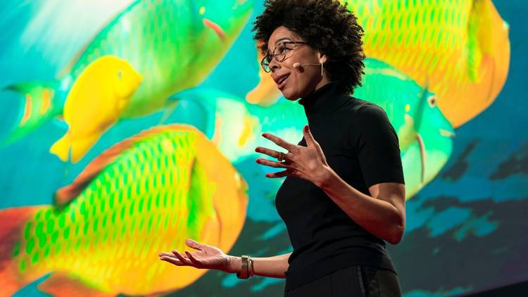 Urban Ocean Lab founder and marine biologist Dr. Ayana Elizabeth Johnson in front of images of brightly coloured fish
