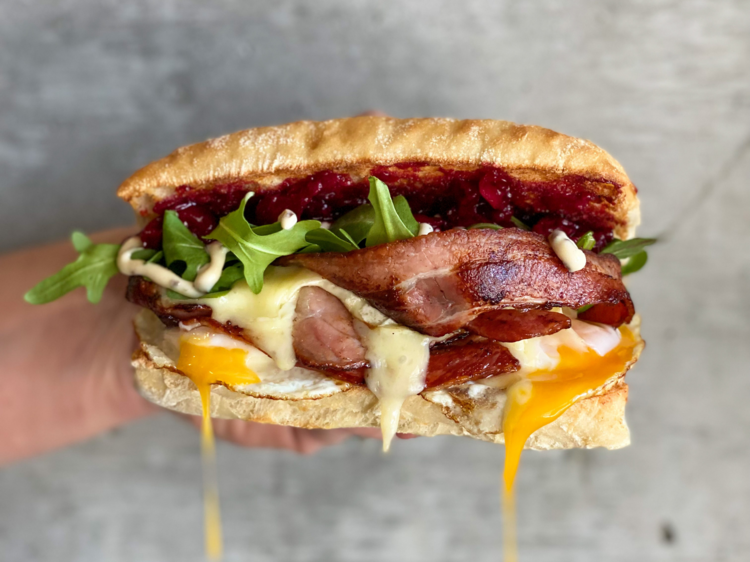 A bacon and egg roll with beetroot relish and rocket 