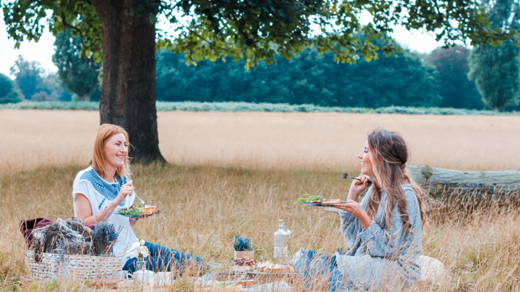 Two people enjoy a picnic outside