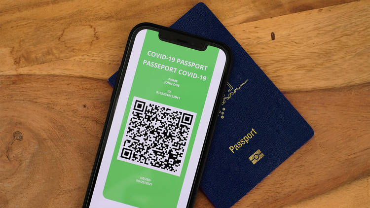 A phone screen with a QR code lays on top of a dark blue Australian passport