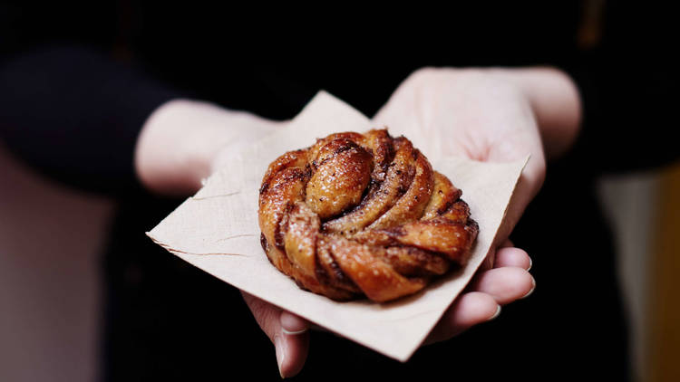 Woman in black holding a pastry in her palms