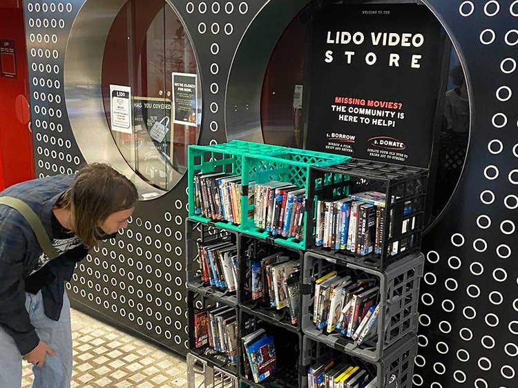 A man browsing the DVD and VHS library outside of Lido Cinemas.