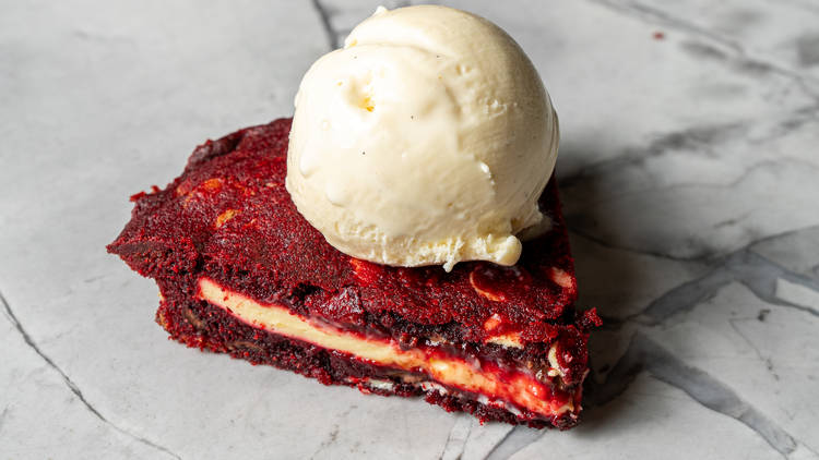 Red velvet cookie pie topped with vanilla ice cream