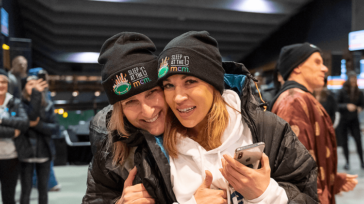 Two women wearing sleep at the g beanies.