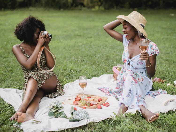 Two women having a picnic outdoors.