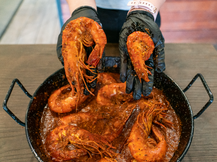 a black bowl of cajun style prawns