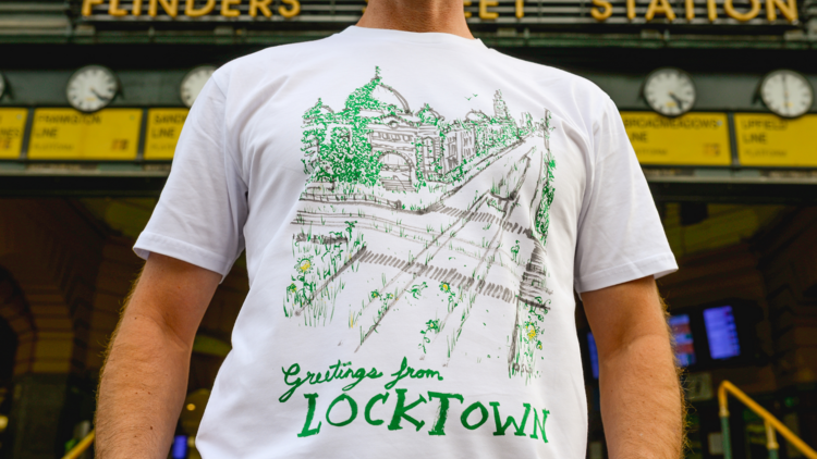 A masked man standing in front of Flinders Street Station wearing a 'Locktown' t-shirt.