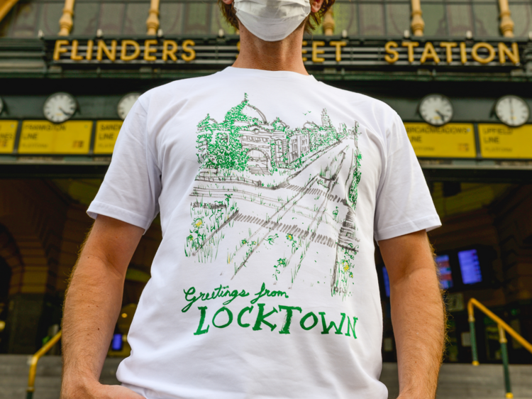 A masked man standing in front of Flinders Street Station wearing a 'Locktown' t-shirt.