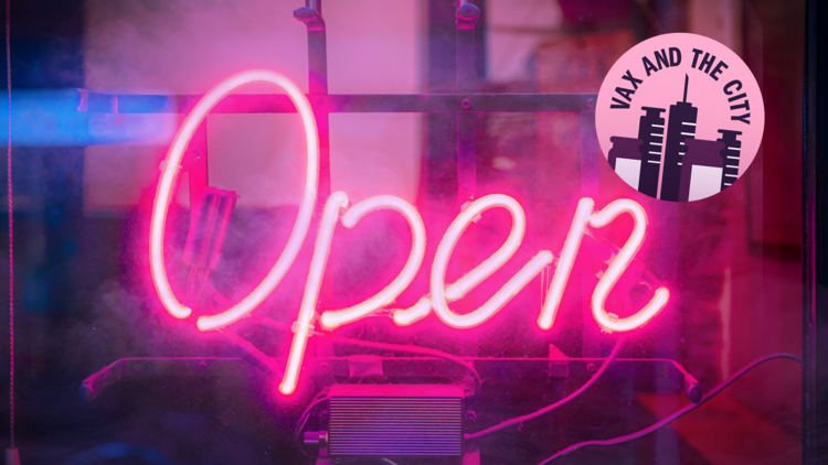 A glowing pink neon sign that reads open against a glass window