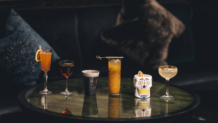 Photograph: Six cocktails lined up on a low round table at Casa Wardour