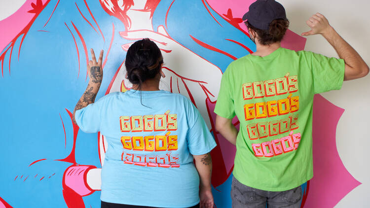 Two of Gogo's Staff members in colorful shirts against a Virgin Mary backdrop.