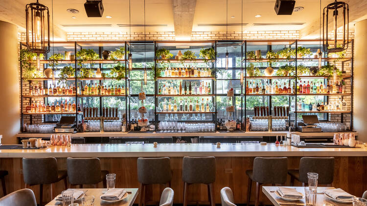The gleaming, all-glass and plant-laden bar at Etta Culver City.