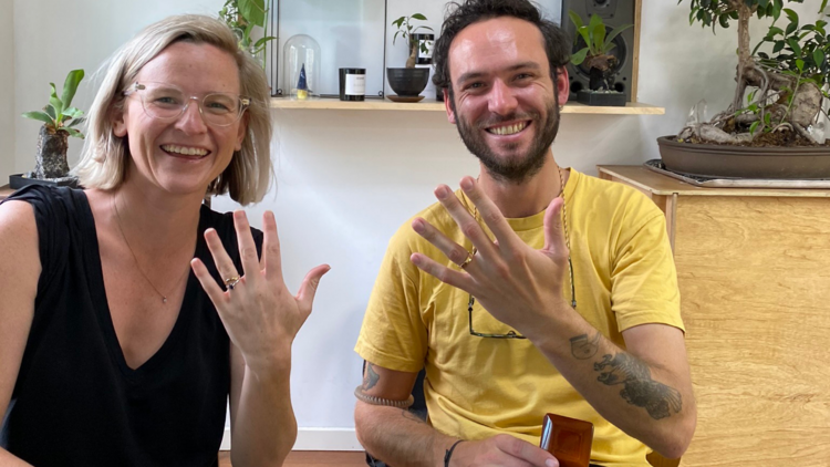 A man and a woman showing off rings made by Corky Saint Clair.