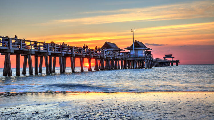 Naples Pier on the beach at sunset in Naples, Florida, USA