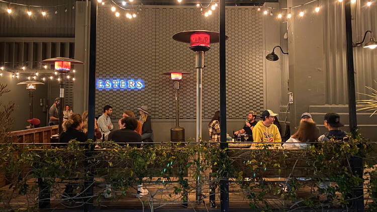 The patio at Ester's Wine Shop and Bar in Santa Monica, with string lights and a heat lamp.