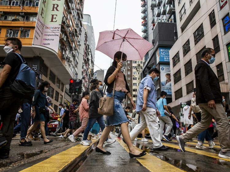 Pedestrians walk on a street in the Wanchai district of Hong Kong on August 6, 2021 