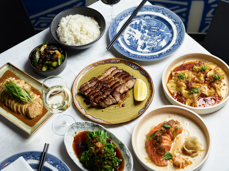 A Chinese banquet of char sui pork, sashimi rice and dumplings on a white table cloth