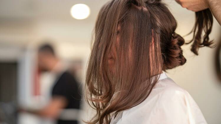 A woman getting her hair styled.