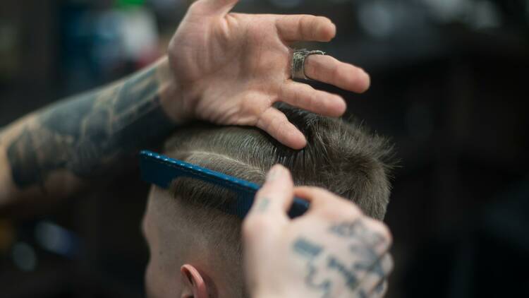 A man giving another man a haircut.