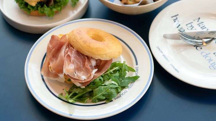 Doughnut sandwich served with Scrambled eggs & Prosciutto 