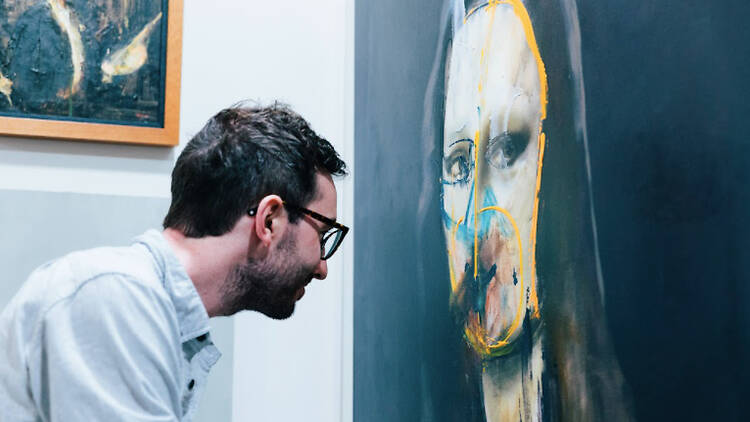 A man looking at an artwork that reimagines the 'Mona Lisa'