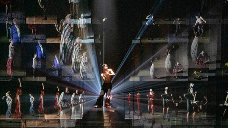 A man dances and the image of many more dancers appears to radiate out form him in a darkened warehouse