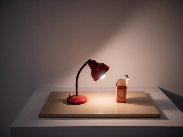 Exposição Matéria Luminal candeeiro vermelho a iluminar embalagem de cartão