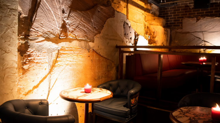 Candlelit sandstone walls with armchairs and round marble tables