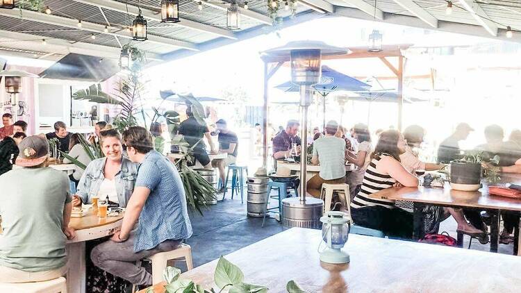 The beer hall at the Ascot Lot. Several people sitting at tables having a drink.