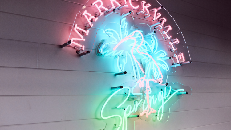 A neon sign reads Marrickville Springs with a palm tree in the centre