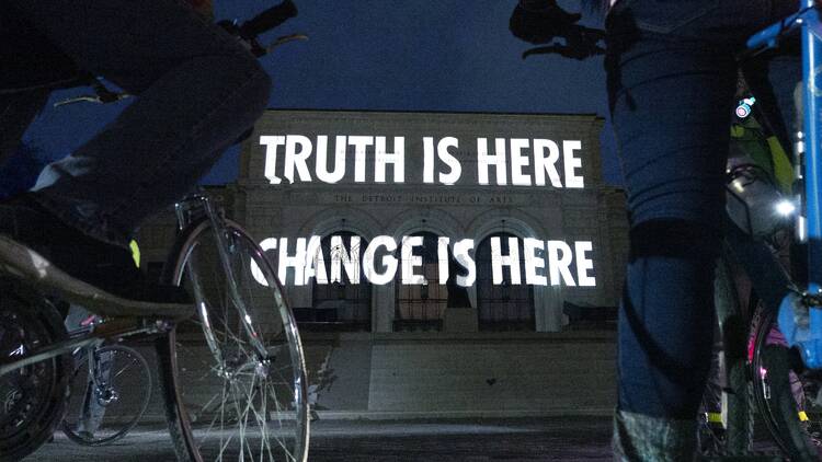 Jenny Holzer projects the words 'Truth is here Change is here' onto the Detroit Institute of Arts