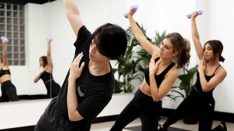 Three people working out in a fitness studio.