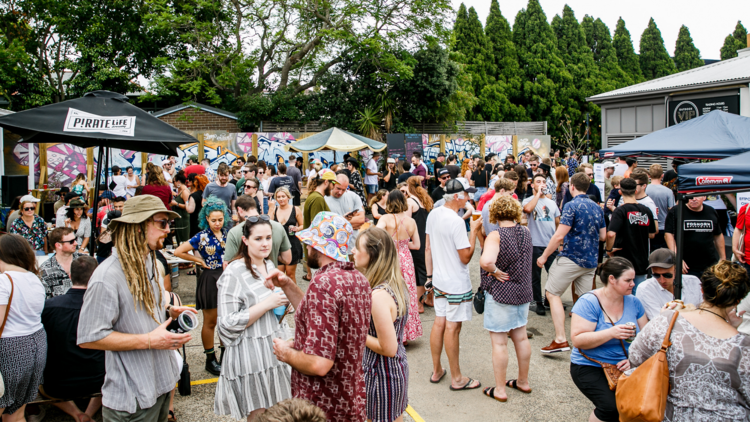 A crowd is gathered at a car park party at the Public House Petersham
