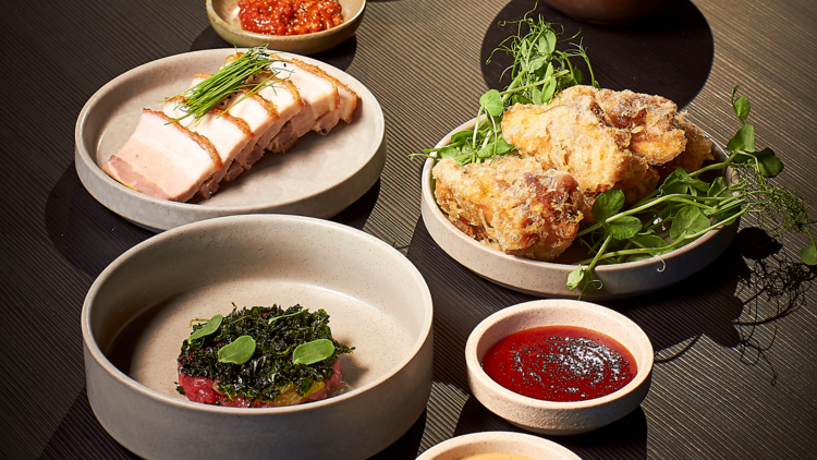 A series of Korean snacks in bowls on a dark wood stained table