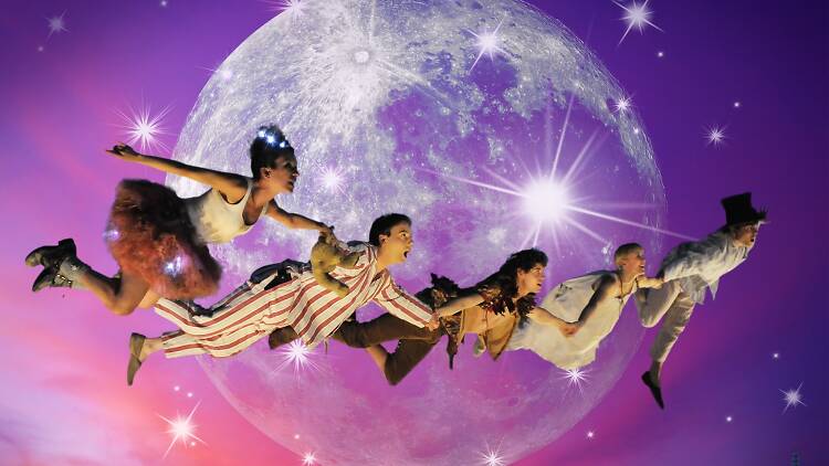 The cast of Peter Pan – The 360° Adventure flying over the city of Melbourne with a giant moon in the background