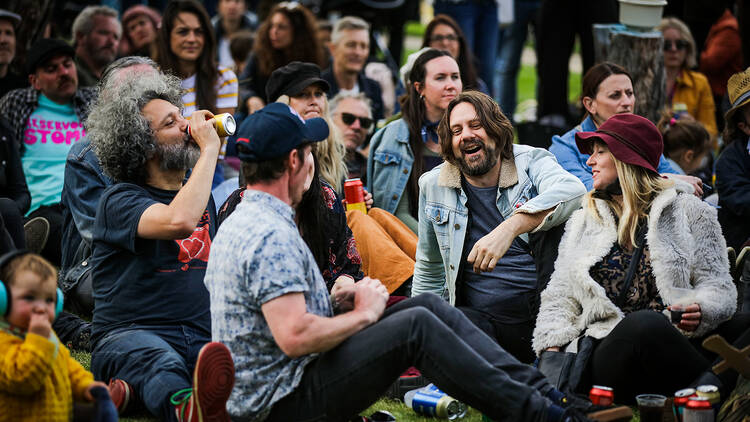 A group of people sitting on the lawn at a previous Reservoir Stomp event.