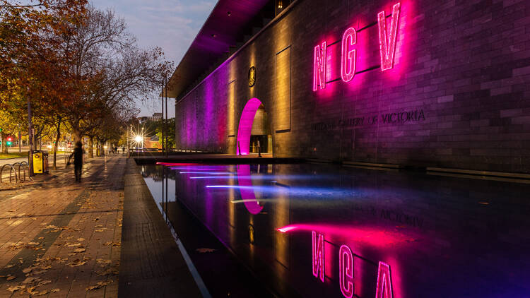 The exterior of the National Gallery of Victoria lit up with neon lights.