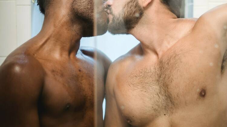 Two men kissing in a sauna