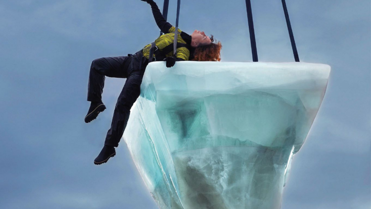 A person is suspended on a large block of ice