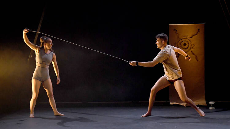 Isabelle Champagne-Chittick and Harley Mann pulling toying with a long thin rope in Common Dissonance