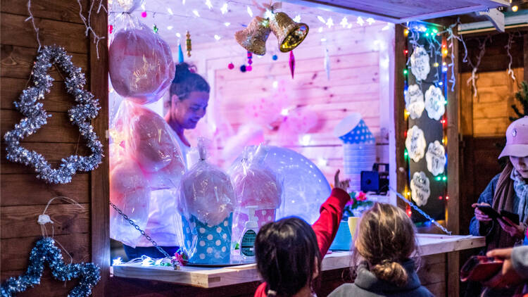 Children gathering around a festival candy stall