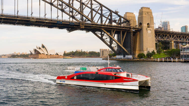 Aerial view of a ferry in the water under the sydney harbour bridge