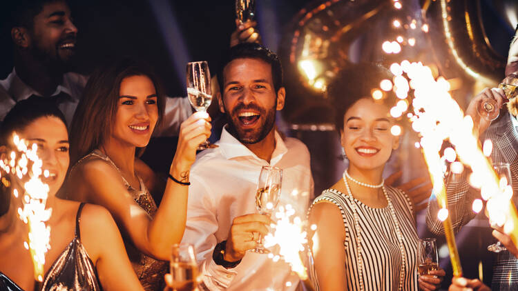 A group of people celebrating on new year's eve with champagne and sparklers