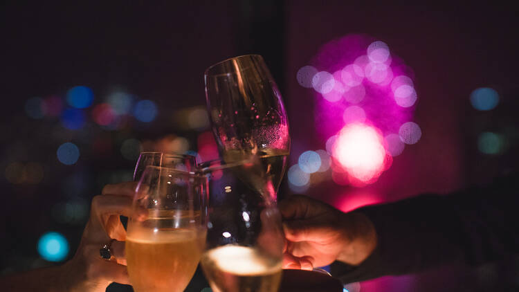 A close-up photo of three champagne glasses cheersing