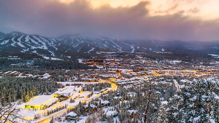 A photo overlooking the town of Breckenridge, Colorado, covered in snow at dusk.