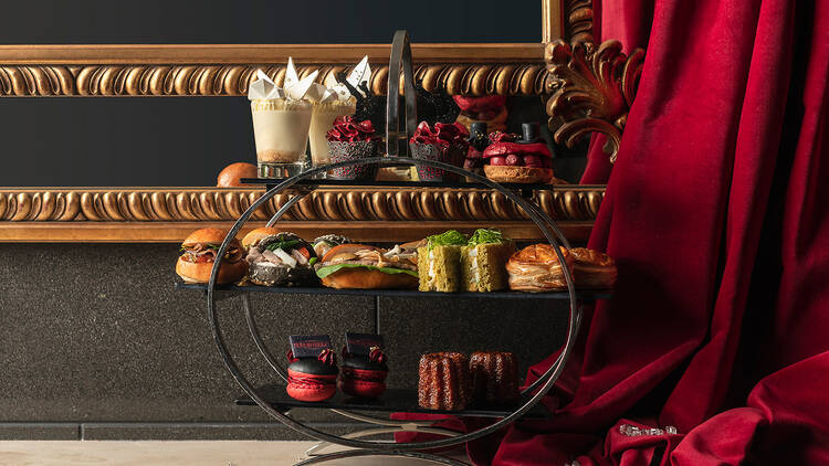 A three-tier high tea platter paired with glasses of sparkling.