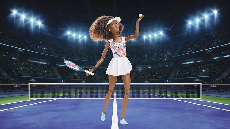 A photo of the Naomi Osaka Barbie on a digital rendering of a tennis purple court.