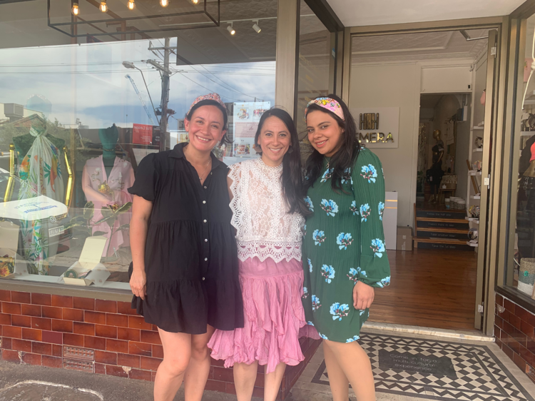 Three of the women who run She Club standing in front of the store.