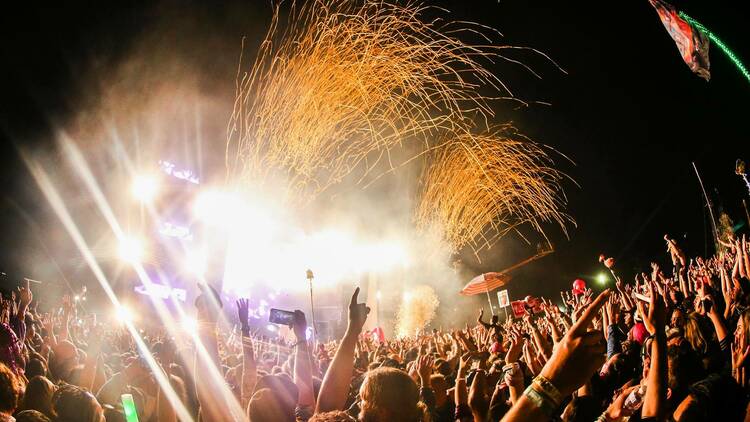 Fireworks taking place over a main stage.