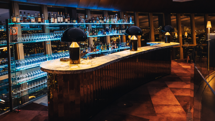 An art deco style bar with domed lamps and red carper